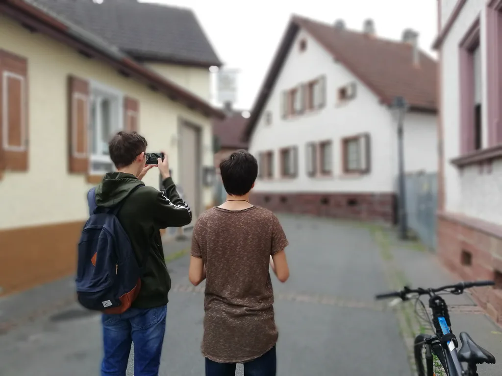 Zwei Jugendliche fotografieren in einer Altstadtgasse.